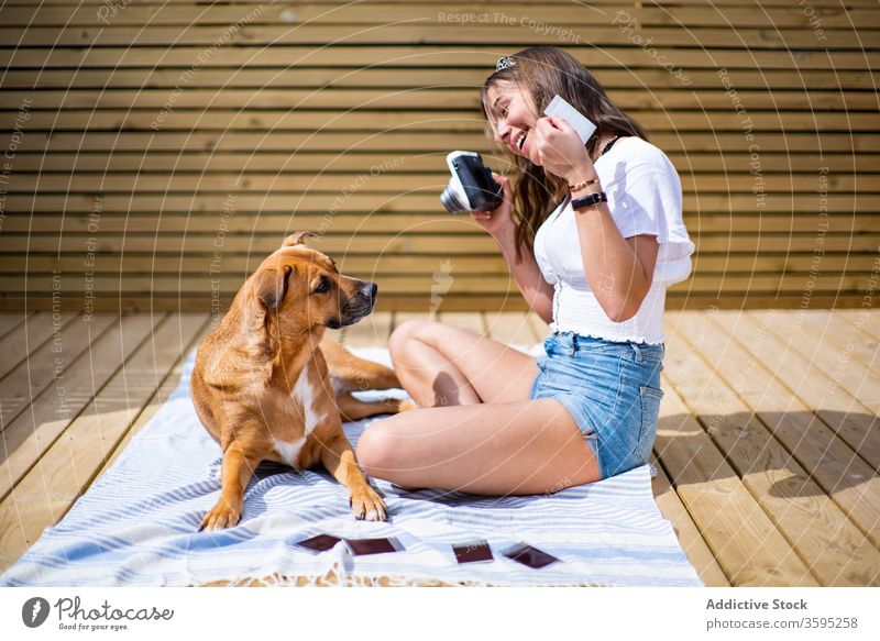 Cheerful woman taking photo of dog take photo summer cheerful together instant photo camera happy friend young positive female owner sunny terrace rest