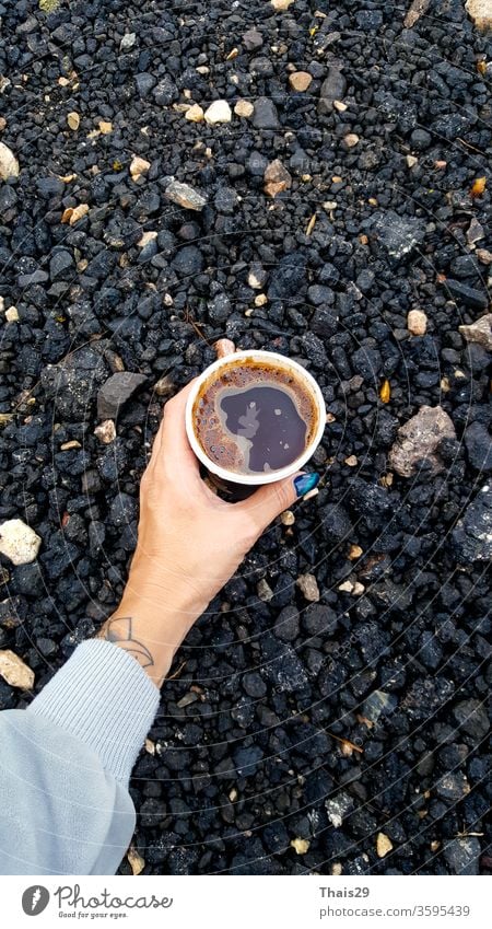 Hand holding fresh hot coffee cup on the ground, morning hiking, travel cafe drink glass hand delicious brown food cool refreshment beverage caffeine cold sugar