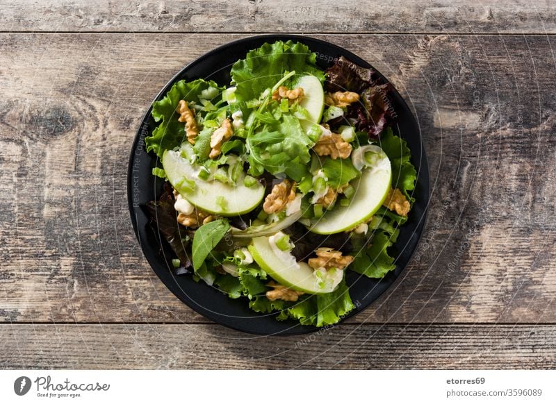 Fresh Waldorf salad with lettuce, green apples and walnuts on wooden table top view american autumn celery cheese delicious diet diner food fresh fruit healthy