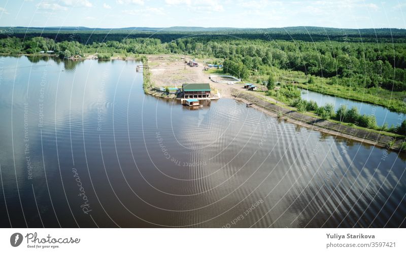 Aerial view of river Kama, Perm krai, Russia. Rural landscape from above, waves and ripples in the water, cloud reflection in water, trees on the coast, summer sun day. Copy space.