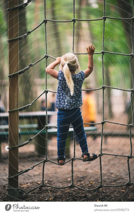 Playground - girl climbing up a climbing net climbs Joy fun Euphoria Tall courageous Brave To hold on detaining Responsibility dare high up upstairs Above
