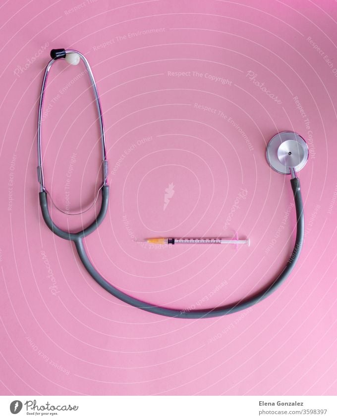 Top view of medical concept with stethoscope and syringe on pink background for coronavirus prevention. Covid-19 kit. Copy Space vaccine Flat lay covid covid-19