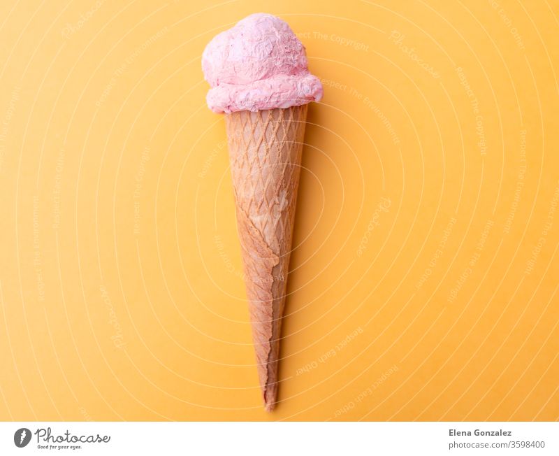 Close up strawberry ice cream in waffles cone on orange background. Copy space. product refreshing copy space flavors conceptual seasonal ideas backgrounds ball