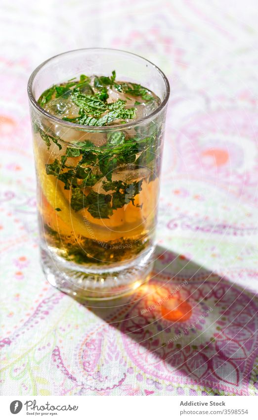 Iced tea with lemon and mint in glasses on table cold ice drink cafe refreshment citrus beverage cool fruit slice liquid cube delicious tasty healthy ingredient