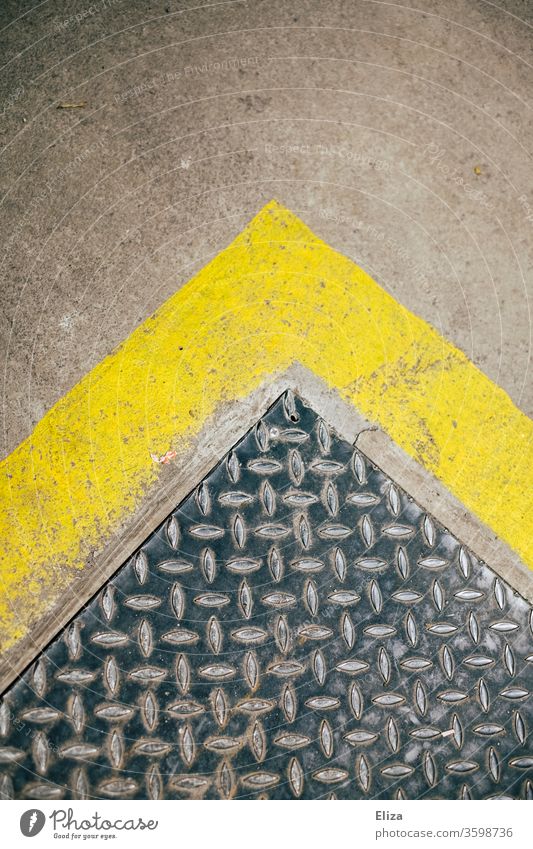 Manhole cover with yellow edge, arrow pointing upwards. Arrow Above Yellow signal colour texture Pattern urban Grunge Abstract surface symbol Direction Surface