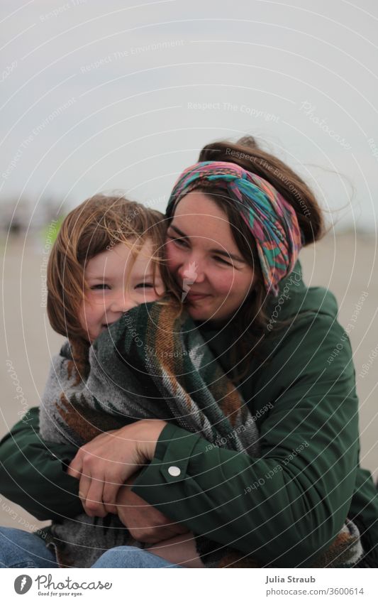 Mother and child on the beach with a fresh breeze Beach Rain jacket Hairband Blanket Ethno patttern green Wind To hold on Pushing Jeans laughing Laughter