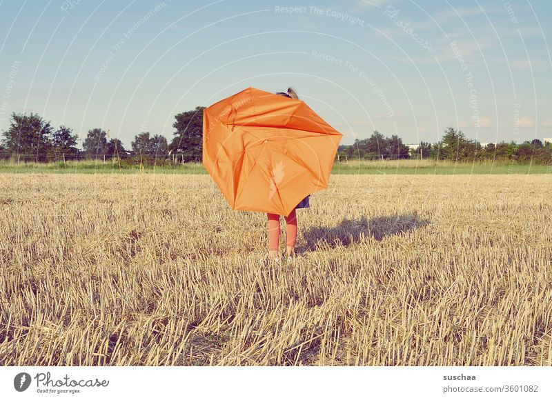 child on a straw chopper with a broken umbrella Child Umbrella Broken Orange acre Field straw field Grain field Agriculture Landscape arable farming Summer