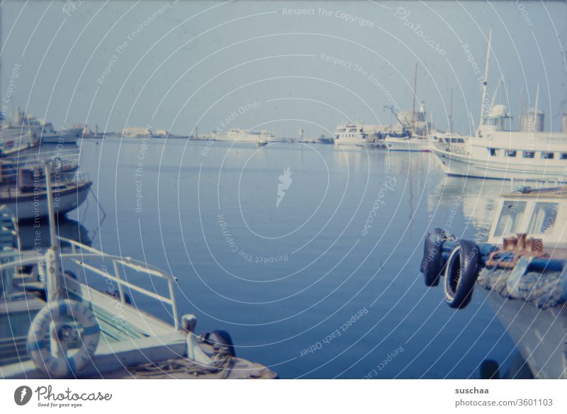 old slide of a marina somewhere in greece Old Retro Slide 70s Ocean Water Blue ägais Greece Harbour boats ships Mooring place Floating tyres Life belt Car tire