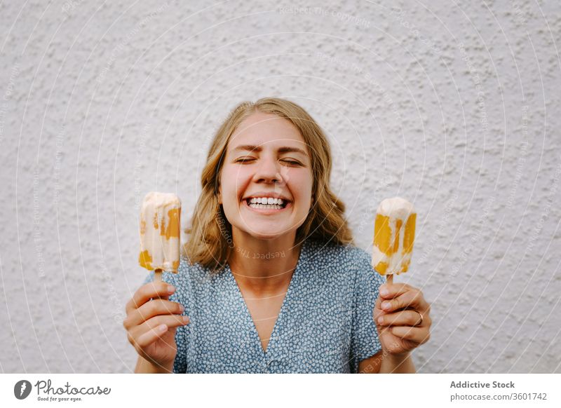 Happy woman with popsicles on white background grimace funny make face ice cream eyes closed having fun lolly tasty smile female cheerful happy joy delicious