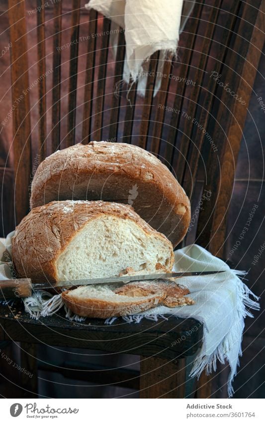 Freshly baked bread on napkin loaf fresh bakery delicious tasty homemade piece aromatic knife sharp wooden chair food cuisine gourmet natural tradition yummy