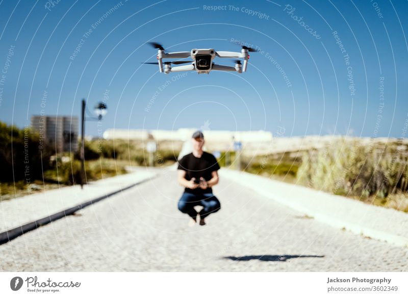 Man holding remote flying together with his drone man flight copter technology concept aladin happiness sunny road outdoor caucasian device multicopter