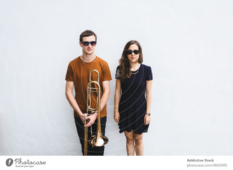 Hipster couple with trombone on white wall street style cool music instrument together relationship musician london hipster vintage england united kingdom sound