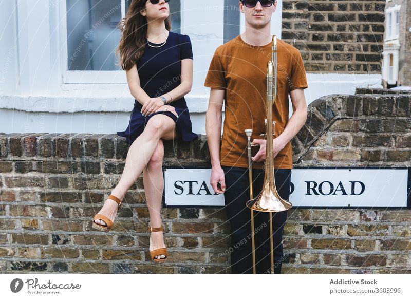 Hipster couple with trombone on city street style cool music instrument together relationship musician london hipster vintage england united kingdom sound love