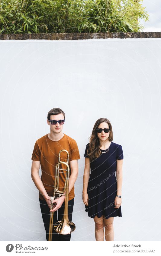 Hipster couple with trombone on white wall street style cool music instrument together relationship musician london hipster vintage england united kingdom sound