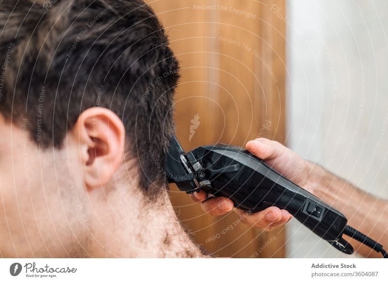 Crop barber doing haircut for man trimmer bathroom men grooming together hairdresser contemporary modern tool hygiene care routine beauty friendship hairstyle