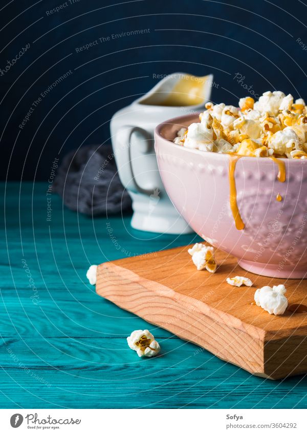 Popcorn with caramel in bowl on dark background popcorn sauce sweet cooked food snack crunchy salty delicious studio tasty ceramic salted cereal jar fluffy