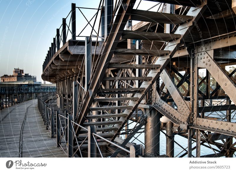 Wooden embankment with metal stairs port wooden quay staircase pier shabby waterfront weathered dock old harbor step timber construction grunge aged structure