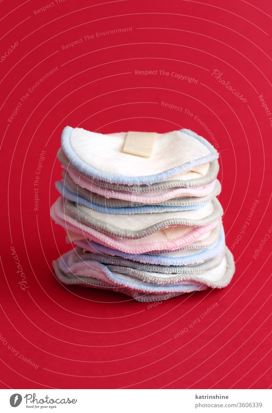 Eco friendly reusable make-up remover pads on red background cotton waste concept close up zero waste alternative cleaning above ecological minimal monochrome