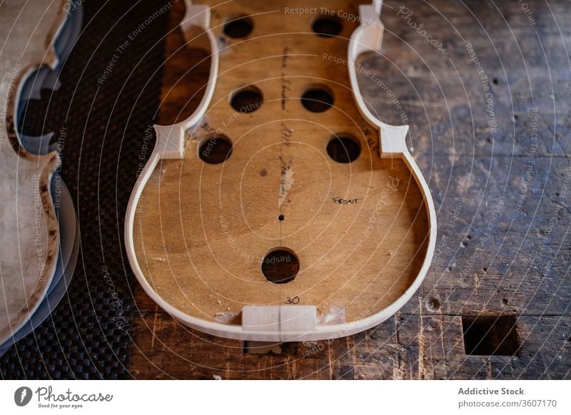 Soundboard of handmade violin on shabby wooden surface in workroom soundboard process workshop hole craft instrument workmanship create detail design