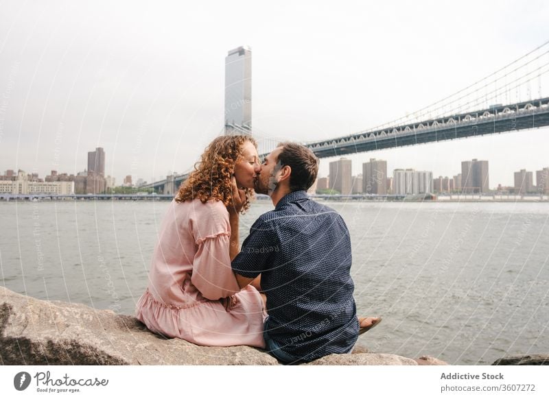 Tender couple kissing on river bank in New York relationship together romantic hug brooklyn bridge tender stroll new york america united states usa city love