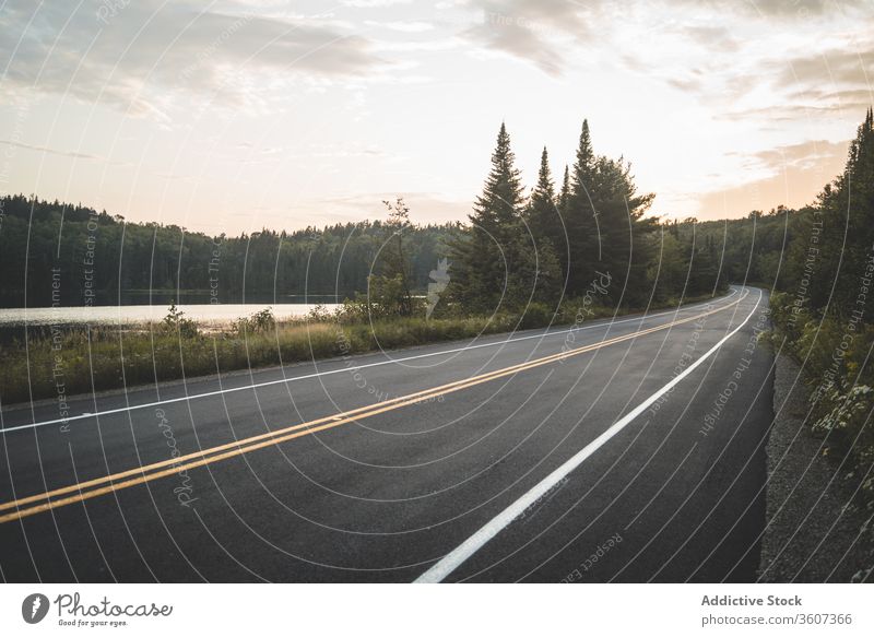 Asphalt road near lake and forest in evening sunset sky cloudy nature national park la mauricie quebec canada asphalt peaceful green calm tranquil countryside