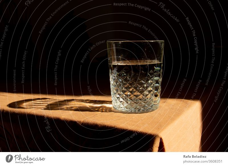 Glass filled with water on brown tablecloth Meal Glassbottle pharmacy glass research Sunlight at home Glasses Water Drinking Light