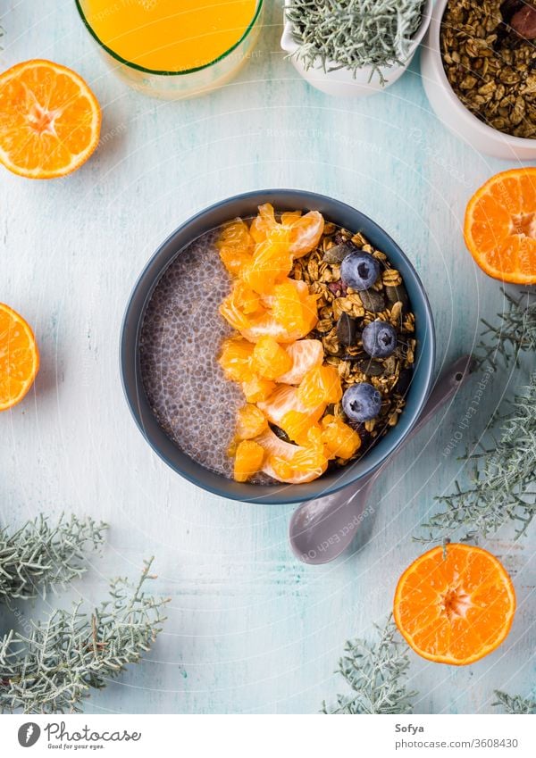 Chia pudding with tangerines and granola chia pudding bowl pastel turquoise matcha tea wooden background blueberry breakfast chia seeds dessert food plant based