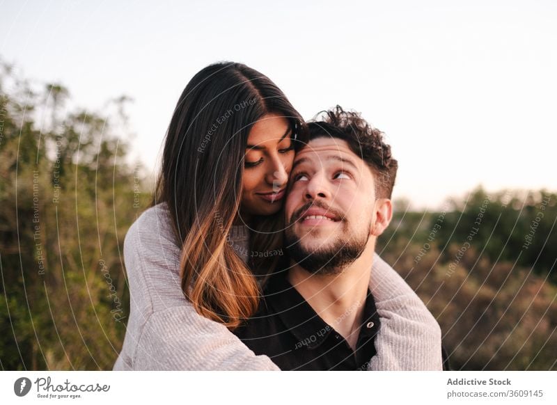 Happy multi ethnic couple hugging in nature laugh joke plaid together relationship in love embrace multiracial multiethnic diverse affection girlfriend