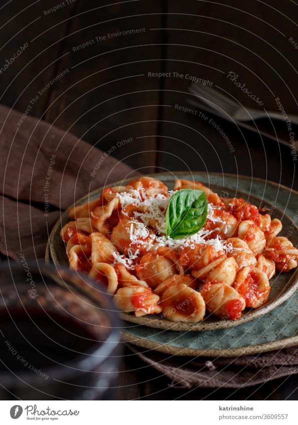 South italian  pasta orecchiette with tomato sauce and cacioricotta cheese apulia tomatoes sugo close up dark brown copy space wooden cooked cuisine diet dinner