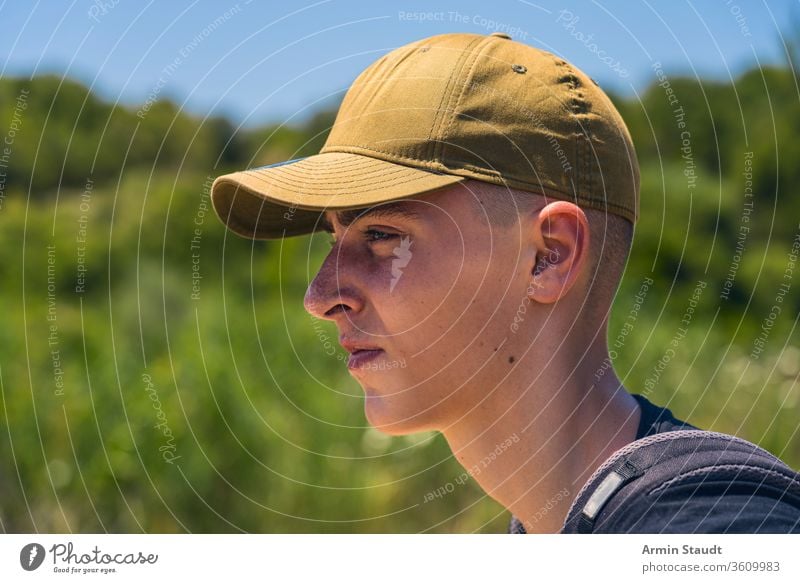 portrait of a young man with base cap in profile aim backpack baseball cap beach beautiful boy casual caucasian confident evening goal green journey lifestyle