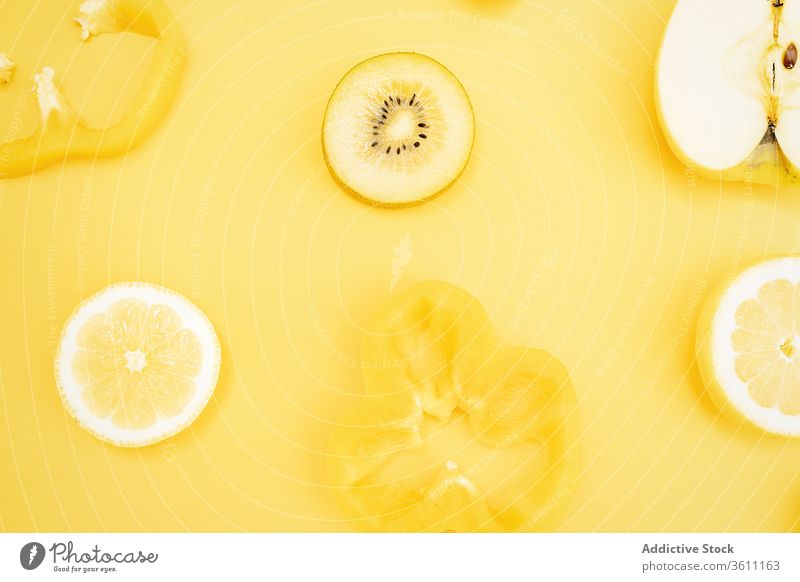 Refreshing fruits on yellow background color vibrant vivid creative healthy food arrangement various composition vitamin citrus organic lemon apple kiwi pepper