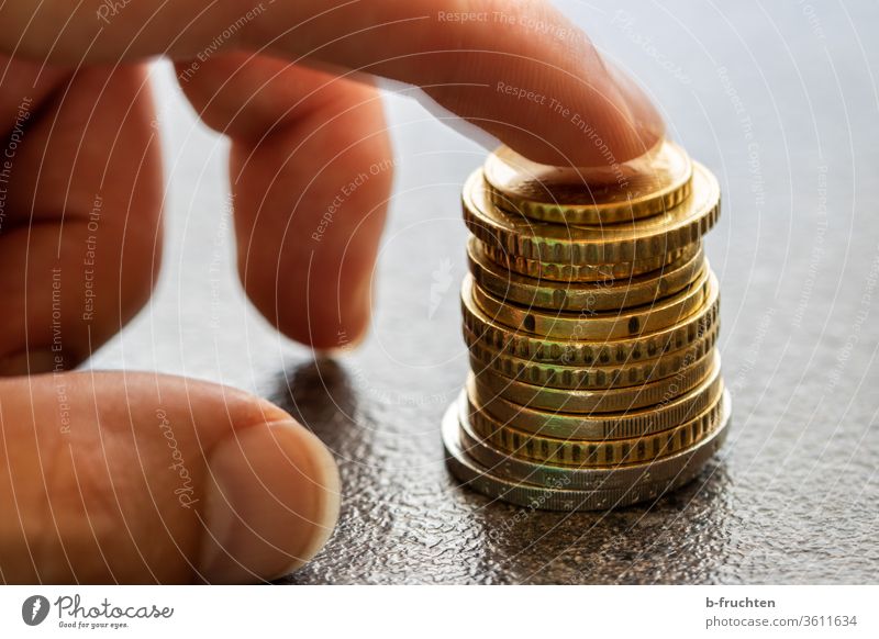A stack of Euro coins Stack Money Loose change Coin Paying Save Income Financial Industry Economy investment by hand Fingers Forefinger stop Close-up savings
