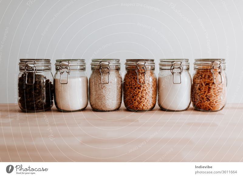 Six glass jars full with dried uncooked food ingredients. Pasta, rice, flour, sugar. container white isolated healthy kitchen product survival covid quarantine