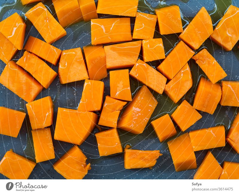 Chopped pumpkin drizzled with oil for baking squash food chop cut pour olive board wooden rustic cooking healthy kitchen fresh vegetable knife vegetarian slice