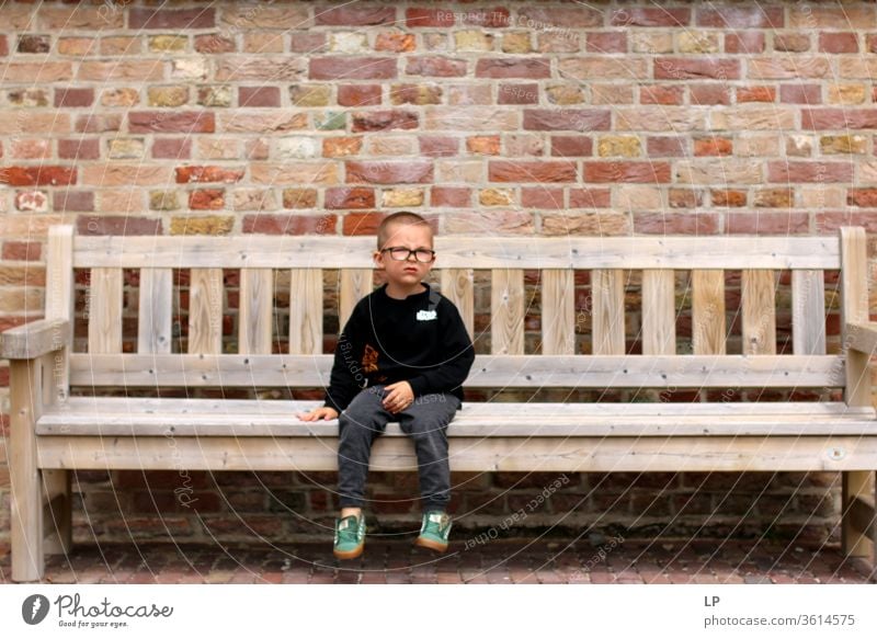 boy sitting down on a bench Loneliness loner Individual alone bank Middle center Separate distressed upset Abandoned Deserted Education Punish waiting time