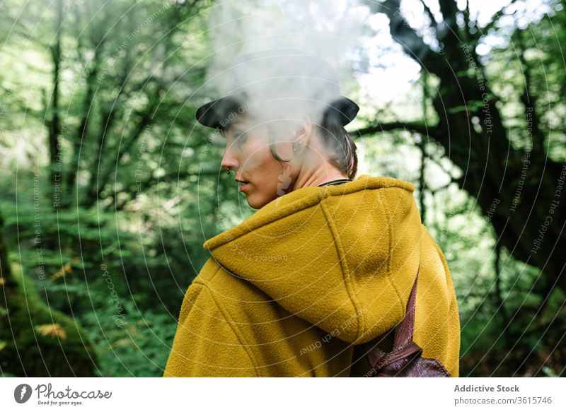 Woman smoking in green forest woman smoke travel style informal exhale tree countryside alternative subculture outerwear relax female nature trendy nicotine