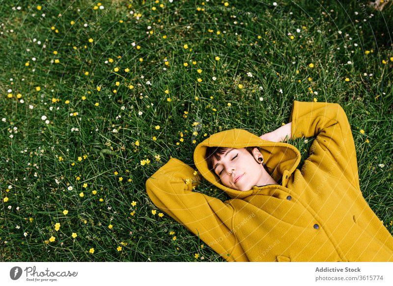Relaxed informal woman lying on meadow relax enjoy summer lawn green piercing brutal carefree female grass rest nature flower cheerful holiday weekend smile