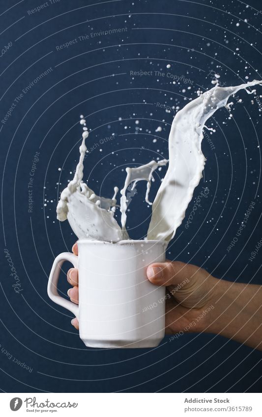 Woman with cup of splashing milk fresh woman dairy drop beverage drink studio female liquid motion move mug ceramic kitchenware tableware creative art modern