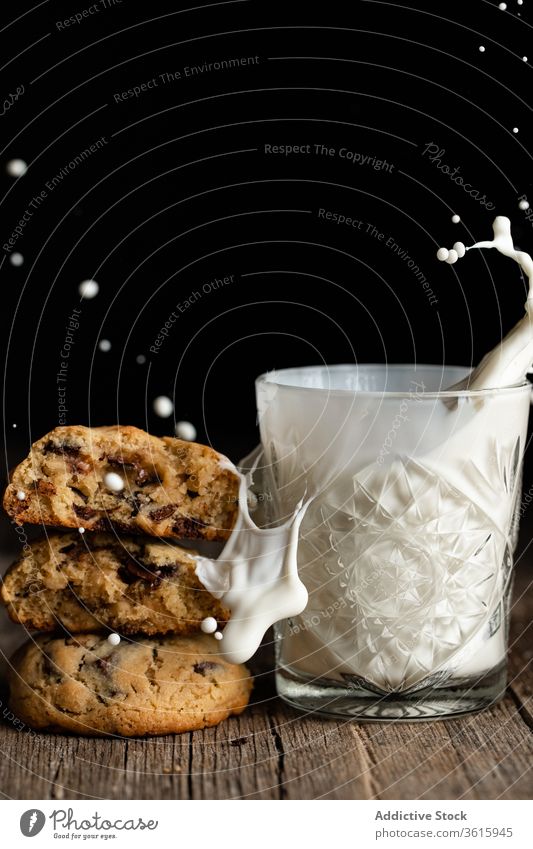 Chocolate chip cookies and glass of milk splash chocolate wooden table tasty pile dessert delicious food drink pastry snack yummy sugar homemade biscuit