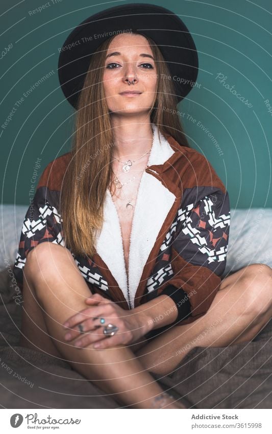 Tranquil woman enjoying morning on bed tranquil dreamy relax style trendy hat female jacket soft sit rest charming calm home bedroom lady harmony peaceful