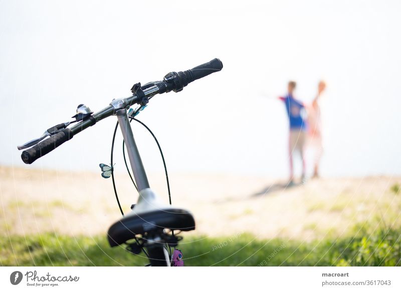 bicycle tour Cycling tour Bicycle Driving children Playing out Nature Landscape blurred Saddle Handlebars Butterfly Close-up Trip Couple couple company