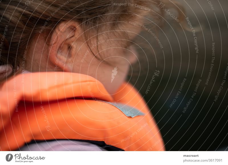 Child with life jacket girl curly-headed Life jacket Vest Safety Water Body of water Close-up Ear portrait Orange