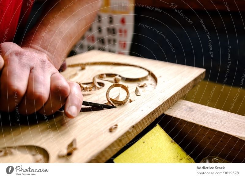 Craftsman carving elements on wood in workshop carve chisel woodwork craftsman ornament tool equipment woodworker artisan male professional occupation job skill
