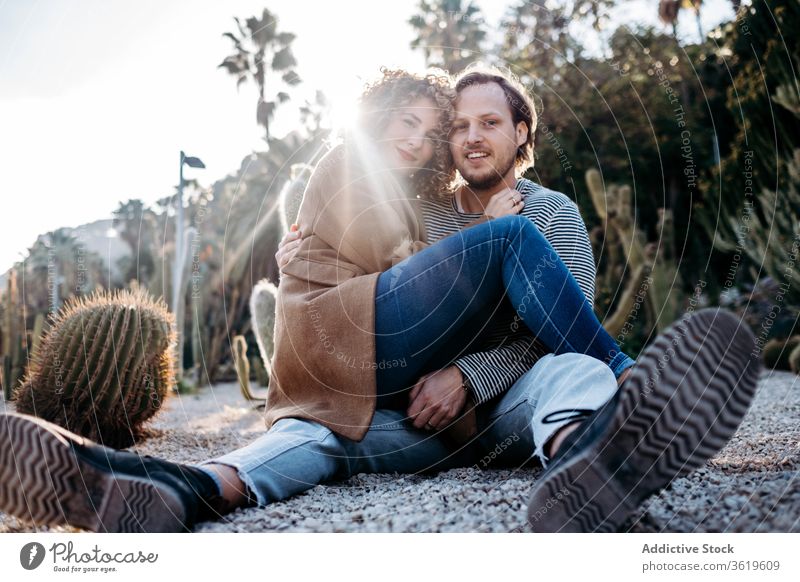 Happy couple hugging in cactus park love happy sunny daytime barcelona spain man woman excited relationship embrace cheerful summer together smile rest romantic