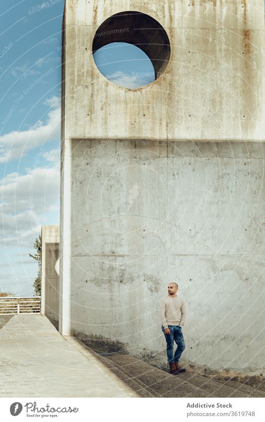 Man standing on stairs near shabby wall man stone construction urban alone hipster modern concrete guy casual male street grunge weathered building step