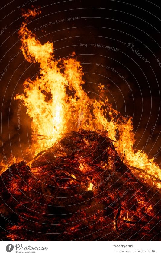 Big bonfire burning in the night heat embers ash resource copy space combustion light light source San Juan spain black background flames orange hot warm danger