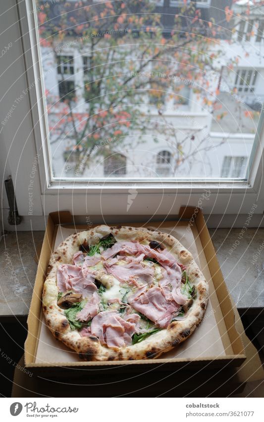 Fresh Pizza in a box at home on the window sill pizza take out take away germany köln cologne food fresh tasty autumn real food authentic nobody vertikal