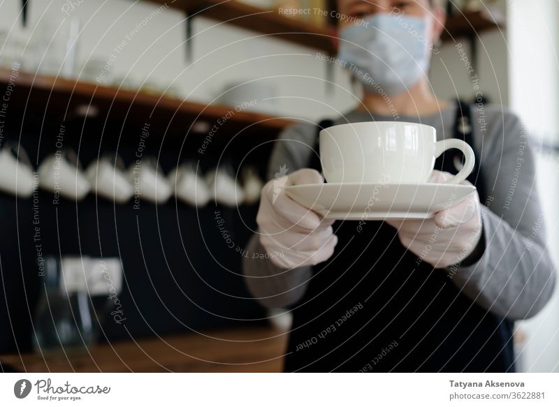 Woman waitress with cup in face mask and gloves coffee female cafe restaurant service apron protective drink woman job cafeteria shop worker staff beverage