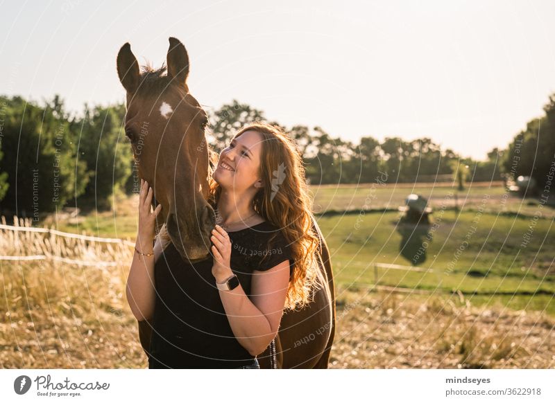 Young woman with horse in the meadow golden light youthful Woman red hair Summer Lifestyle Face people portrait girl Easygoing already Horse Nature Country life