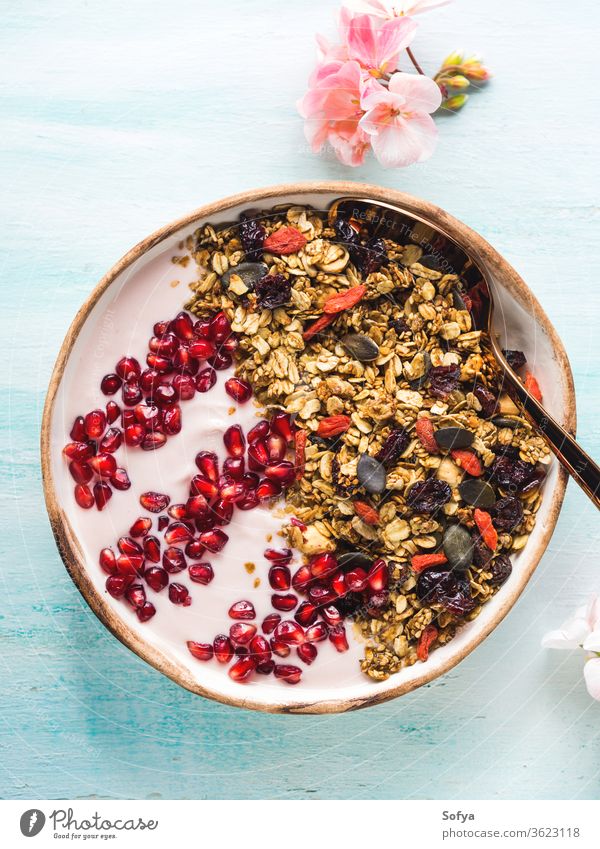 Healthy yogurt bowl with granola and pomegranate healthy berry fruit detox homemade eat top view autumn fall spring flower above breakfast muesli diet food